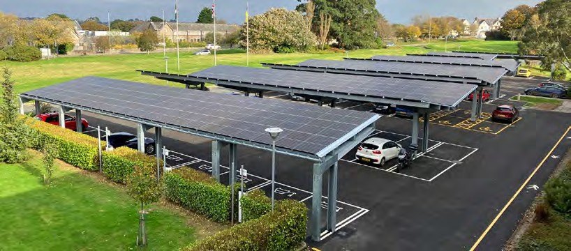 Solar carports over a hotel car park with vehicles charging beneath